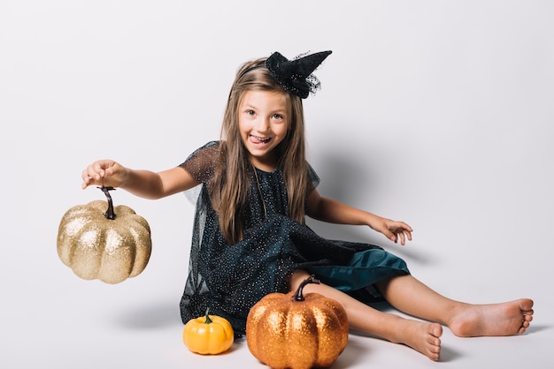 Photo gratuite drôle de sorcière jouant avec des citrouilles