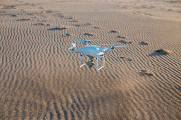 Photo gratuite drone volant atterrissant sur le sable à la plage