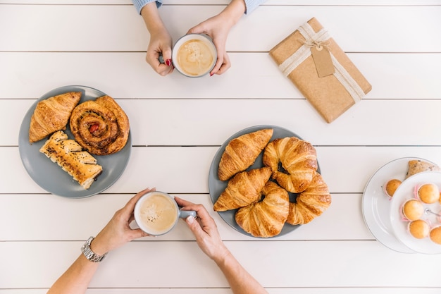 Photo gratuite du dessus des mains de la culture pendant le petit déjeuner