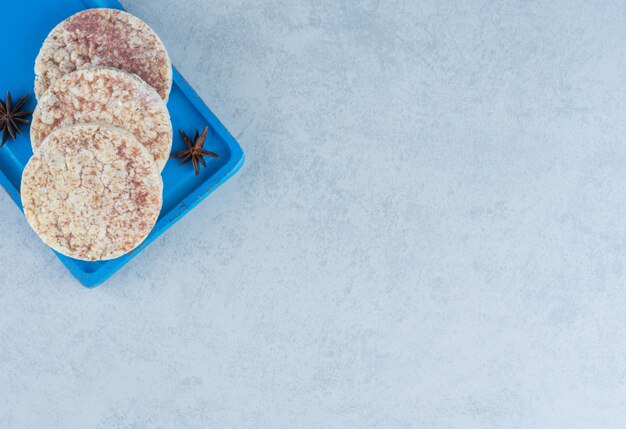 Du gâteau de riz et de la cannelle à bord sur du marbre.