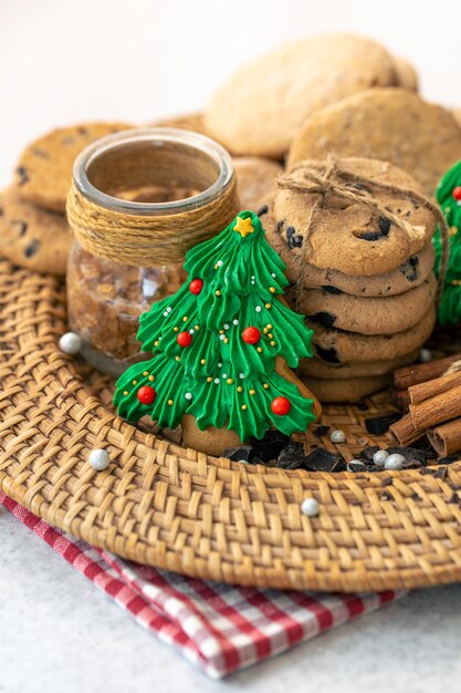 Du pain d'épice en forme d'arbre de Noël et des biscuits dans une assiette en osier