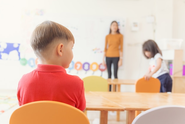 Éducation, école élémentaire, apprentissage et concept de personnes - groupe d&#39;élèves avec enseignant assis en salle de classe. Photos de style effet effet vintage.