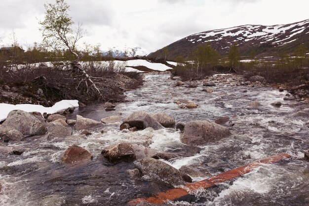 L&#39;eau éclabousse les rochers sur la rivière