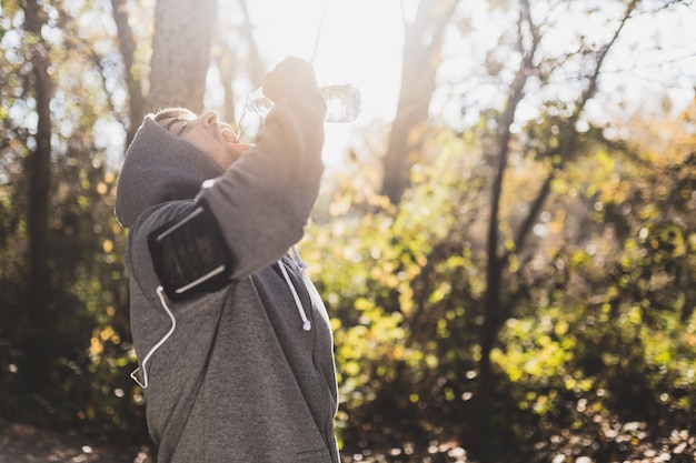 Photo gratuite l'eau potable sportif fit dans le parc