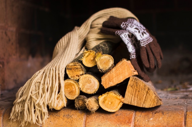 Photo gratuite echarpe et gants sur le bois de chauffage