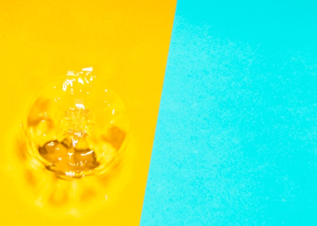 Photo gratuite Éclaboussure d'eau et bulles sur fond jaune et bleu