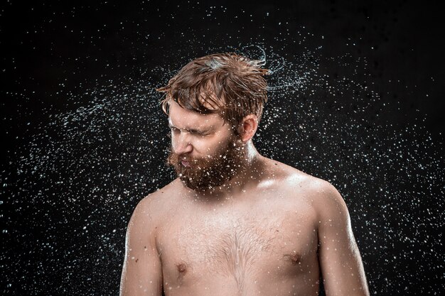 Les éclaboussures d'eau sur le visage masculin