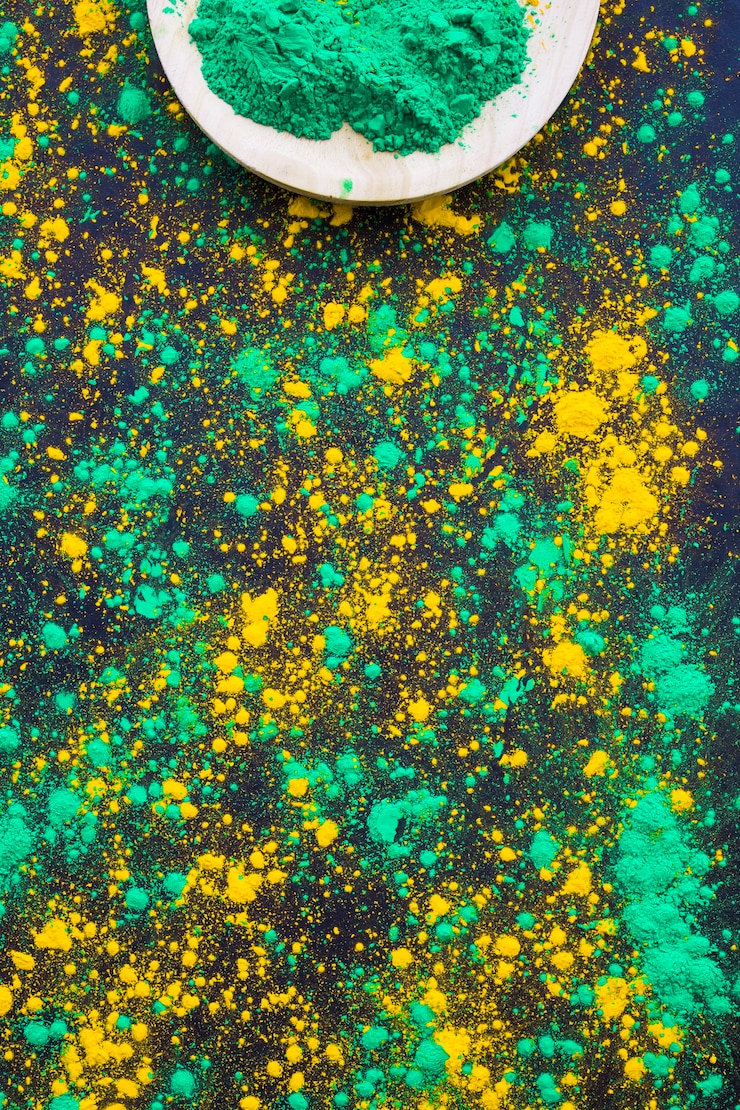Photo gratuit éclaboussures de poudre holi vert et jaune sur fond noir