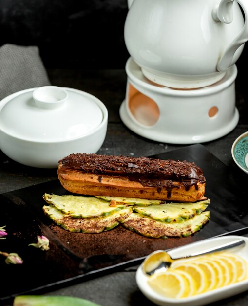 Photo gratuite Éclair au chocolat placé sur des tranches d'ananas