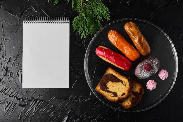 Eclair aux fraises avec muffin au chocolat et livre de recettes.