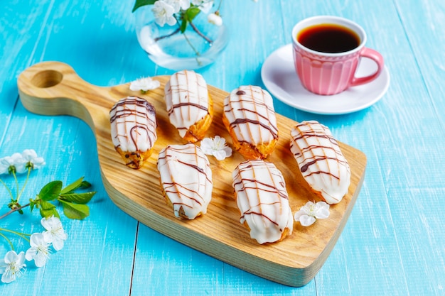 Photo gratuite eclairs ou profiteroles au chocolat noir et chocolat blanc avec crème pâtissière à l'intérieur, dessert français traditionnel.