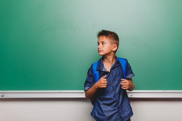 Photo gratuite Écolier posant dans la classe