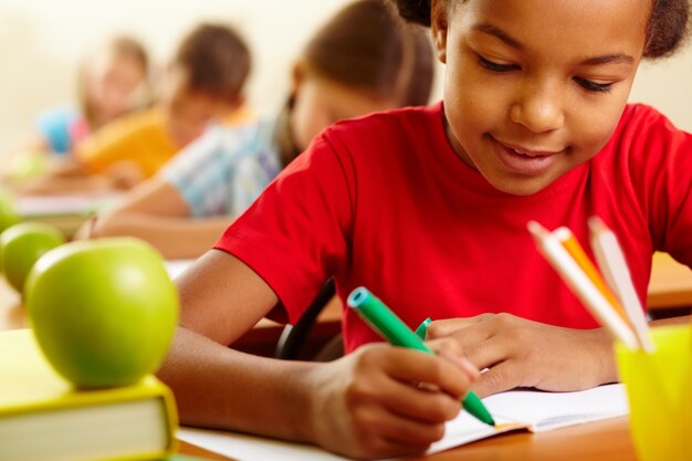 écolière concentré avec un crayon vert