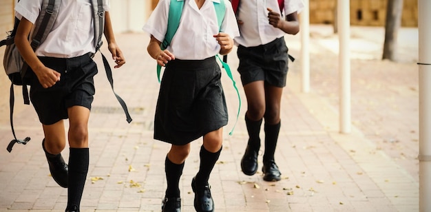 Des écoliers souriants courant dans le couloir à l'école