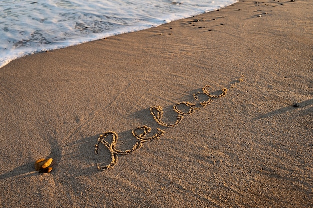 Photo gratuite Écrire des mots dans le sable