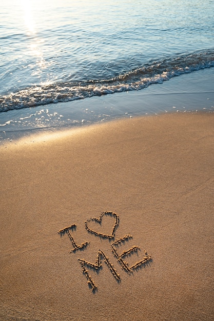 Photo gratuite Écrire des mots dans le sable