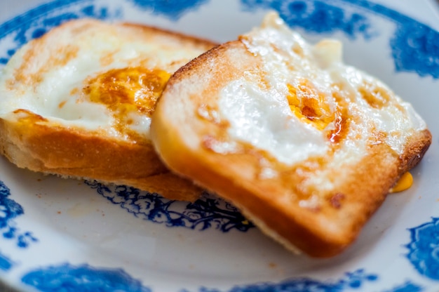 Eggy pain sur le plat, photographié avec de la lumière naturelle. Pain à l&#39;or avec du beurre et des œufs. Petit-déjeuner au pain. Petit déjeuner anglais. Petit-déjeuner sain avec des œufs