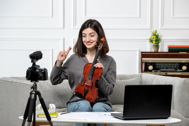 Elearning à distance donnant des cours de violon à la maison jeune jolie belle fille très heureuse