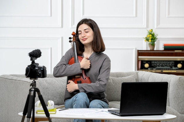 Elearning à distance à la maison donnant des cours de violon jeune jolie belle fille très heureuse