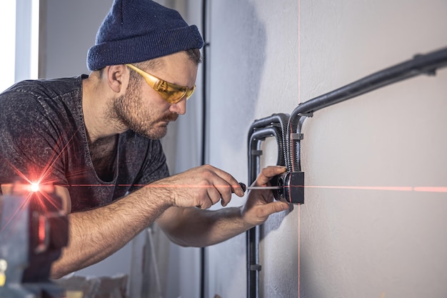 Photo gratuite un électricien monte des prises électriques sur le mur blanc à l'intérieur