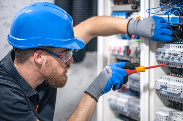 Photo gratuite un électricien qui travaille dans un central électrique avec des fusibles.