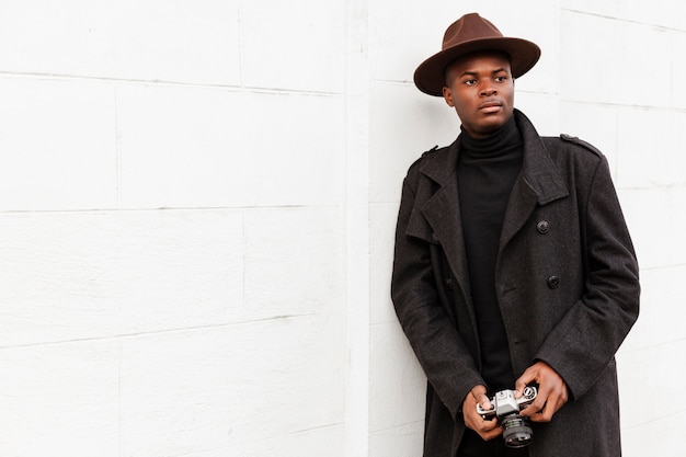 Photo gratuite Élégant jeune homme posant avec un chapeau moderne