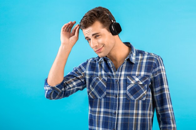 élégant et séduisant beau jeune homme écoutant de la musique sur des écouteurs sans fil