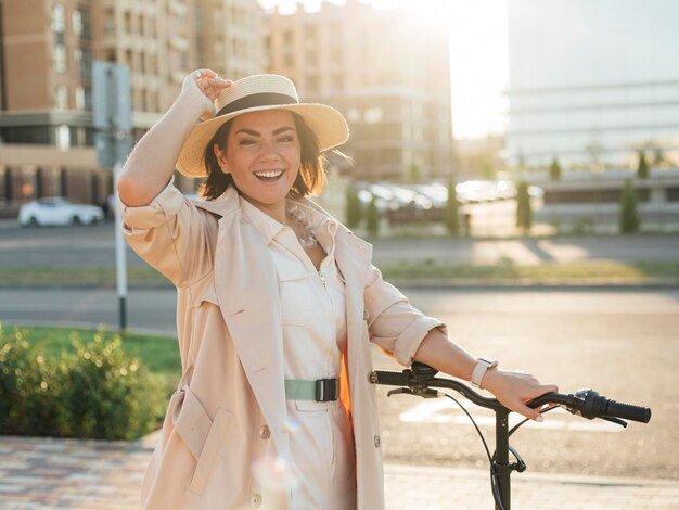 Photo gratuite Élégante femme adulte posant avec vélo écologique