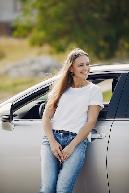 Photo gratuite Élégante femme debout près de la voiture