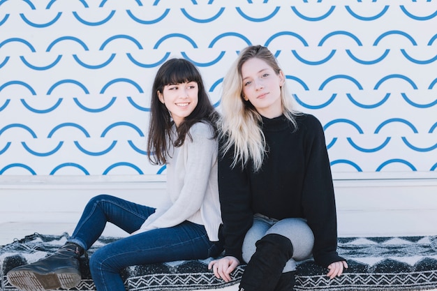 Photo gratuite Élégantes jeunes filles assis sur la rue