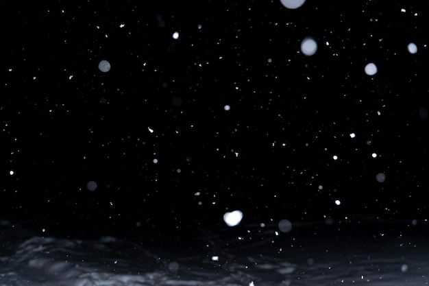 Élément pour la conception ou la superposition d'hiver. de la vraie neige sur fond noir avec une faible profondeur de champ.