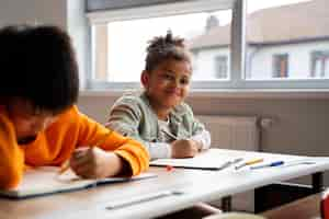 Photo gratuite Élèves apprenant à l'école dans leur classe