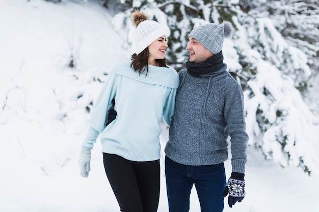 Photo gratuite embrassant un couple marchant dans la forêt