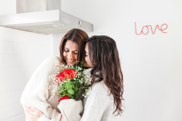 Embrasser des copines heureuse avec bouquet