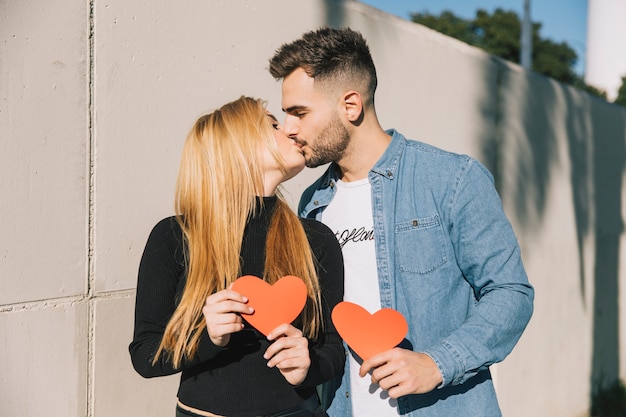 Photo gratuite embrasser un couple au soleil avec coeur de papier