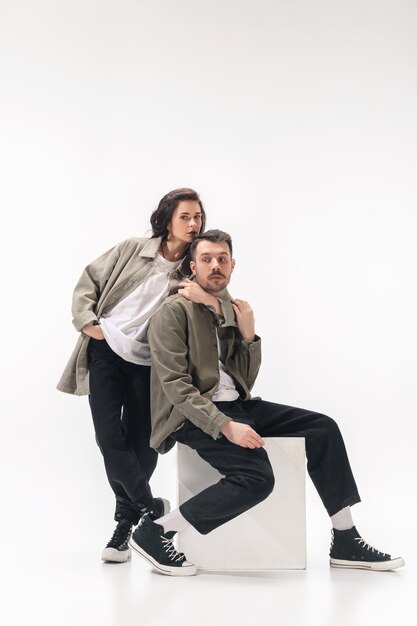 Embrasser. Couple à la mode branché isolé sur fond de studio blanc.