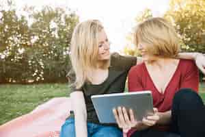 Photo gratuite embrasser les femmes avec une tablette en se regardant