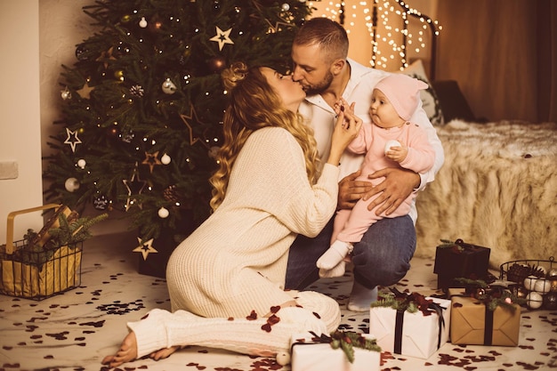 Embrasser les parents et le bébé à Noël.