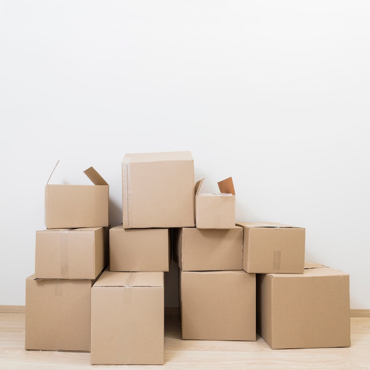 Photo gratuit empilé de déplacer des boîtes en carton contre le mur blanc