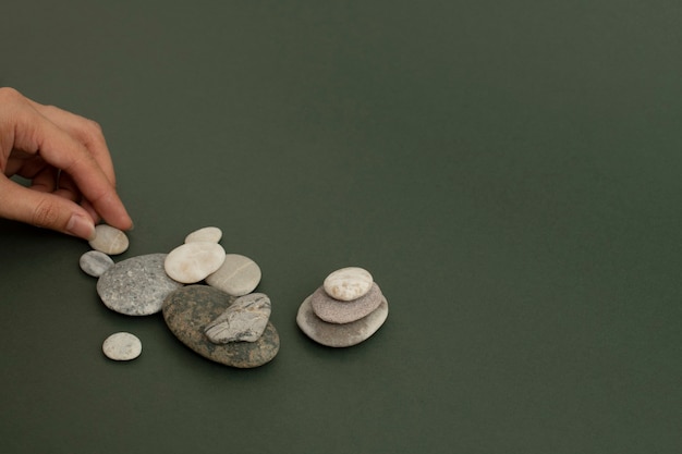 Photo gratuite empiler des pierres zen à la main sur le fond de bien-être du sable