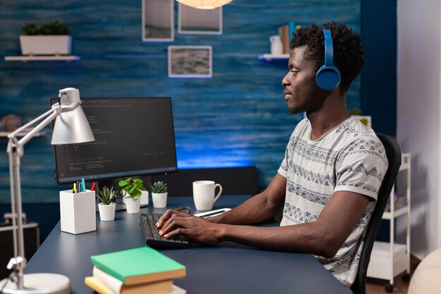 Employé afro-américain avec casque travaillant à distance depuis la maison