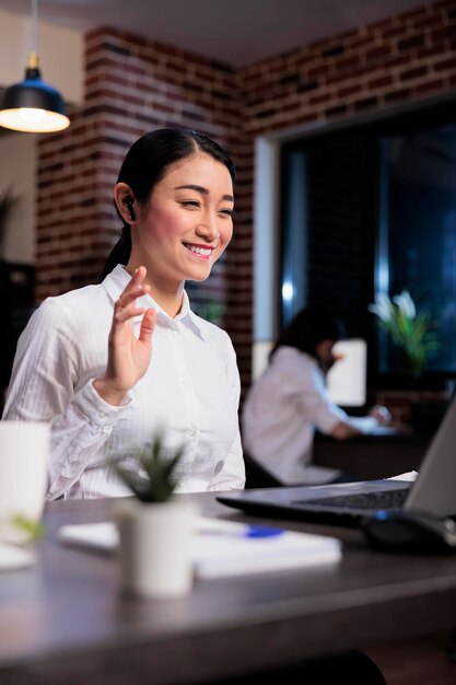 Employé d'une agence de marketing lors d'une réunion en ligne avec un leader financier dans un espace de travail de bureau. Femme d'affaires asiatique en visioconférence à distance avec le directeur exécutif discutant du budget de l'entreprise.