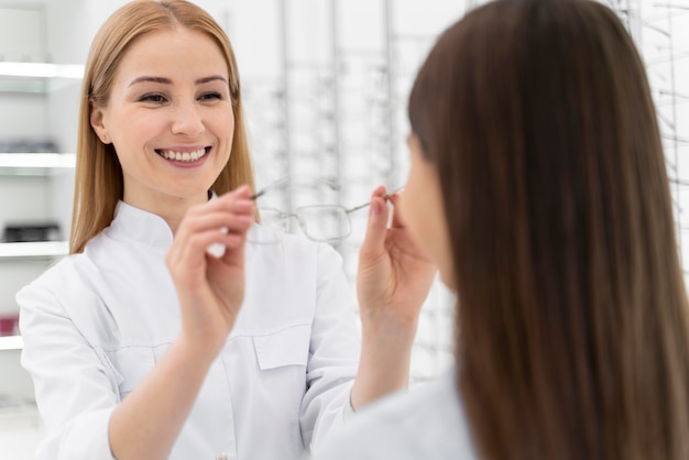 Employé aidant une fille à essayer des lunettes