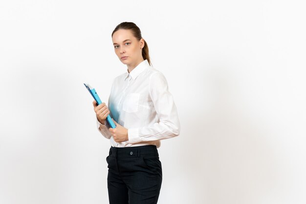 Employé de bureau féminin en chemisier blanc tenant des documents sur blanc