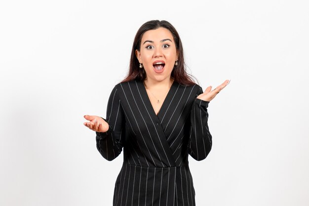 Employé de bureau féminin en costume noir strict sur blanc