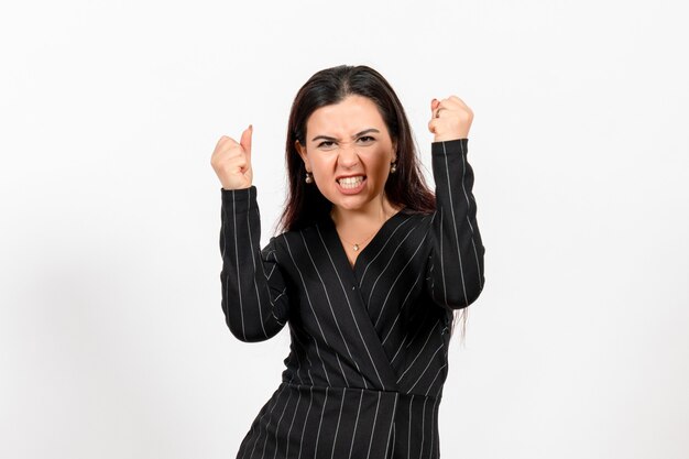 Employé de bureau féminin en costume noir strict avec visage émotionnel sur blanc