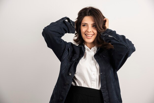 Employé de bureau femme posant avec veste sur blanc.