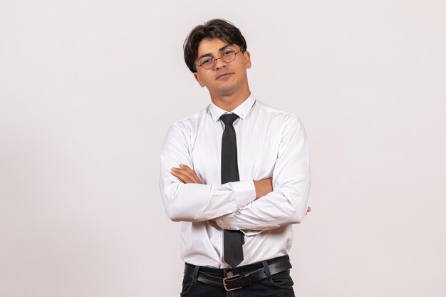 Employé de bureau masculin de vue de face posant sur le travail humain de bureau de travail de mur blanc