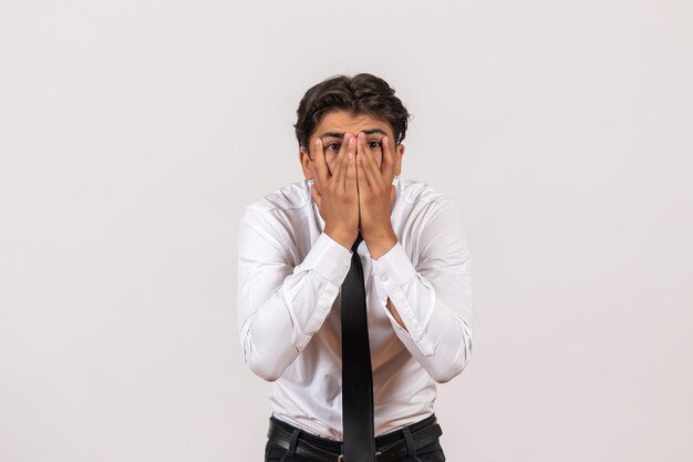 Employé de bureau masculin vue de face avec un visage choqué sur un mur blanc