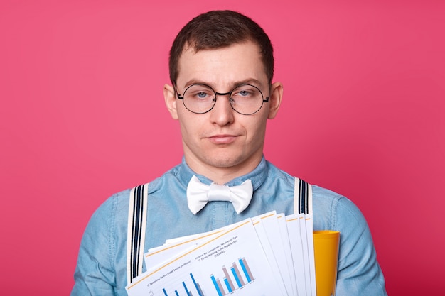 Employé de bureau sans émotion épuisé pose isolé sur rose